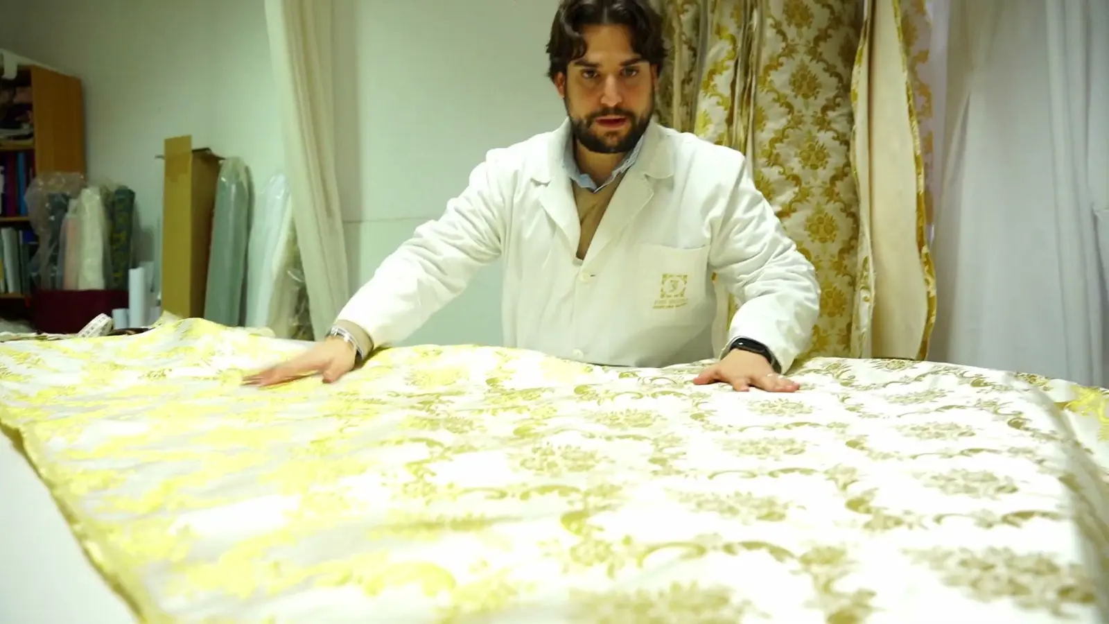 José Segura extiende un tejido bordado en oro en su taller de Jerez