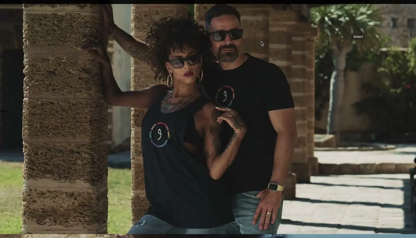 Fotografía de campaña de Gadita en la portada de su tienda online: una pareja con camisetas de la marca entre columnas de piedra